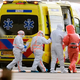 Sanitäter begleiteten eine Person mit Verdacht auf eine Hantavirus-Infektion auf dem Amsterdamer Flughafen zu einem Krankenwagen. - Foto: Peter Dejong/AP/dpa