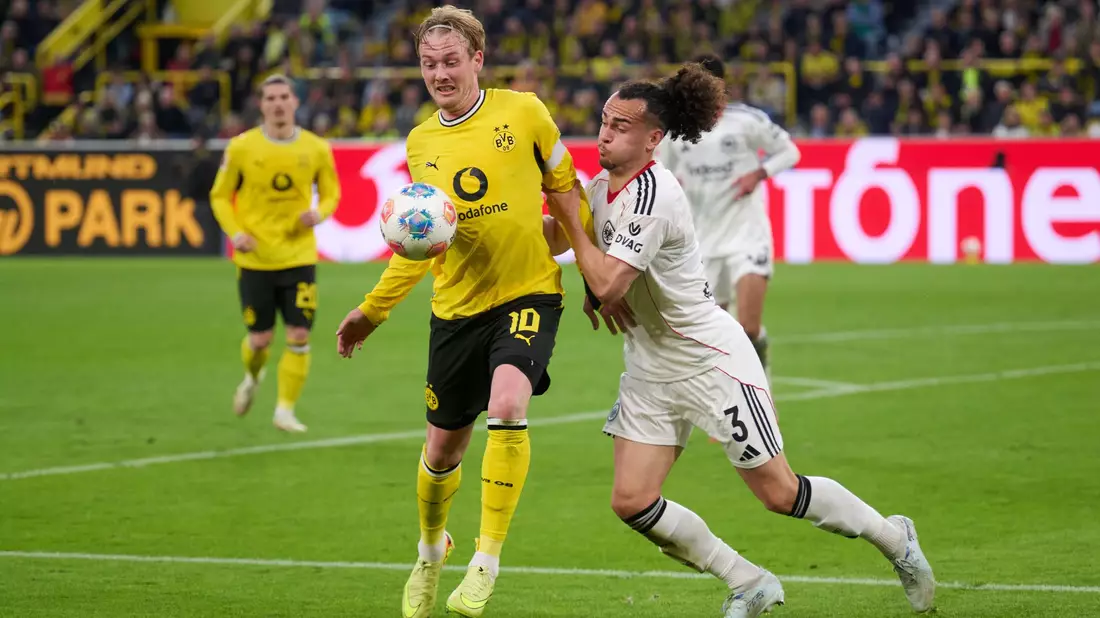 Dortmunds Julian Brandt im Duell mit Frankfurts Arthur Theate.  - Bild: Bernd Thissen/dpa