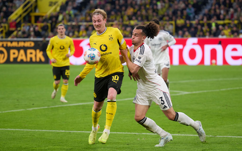 Dortmunds Julian Brandt im Duell mit Frankfurts Arthur Theate.  - Foto: Bernd Thissen/dpa