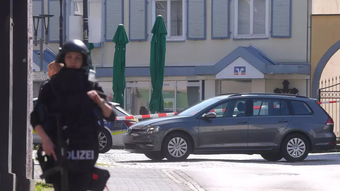 Schwer bewaffnete Einsatzkräfte bezogen Stellung vor der Bank. - Bild: Thomas Frey/dpa