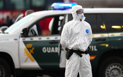 Die Sicherheitsvorkehrungen sind hoch: Ein Mitglied der Guardia Civil, das einen weißen Schutzanzug und Maske trägt, steht auf dem Hafengelände. - Foto: AP/dpa