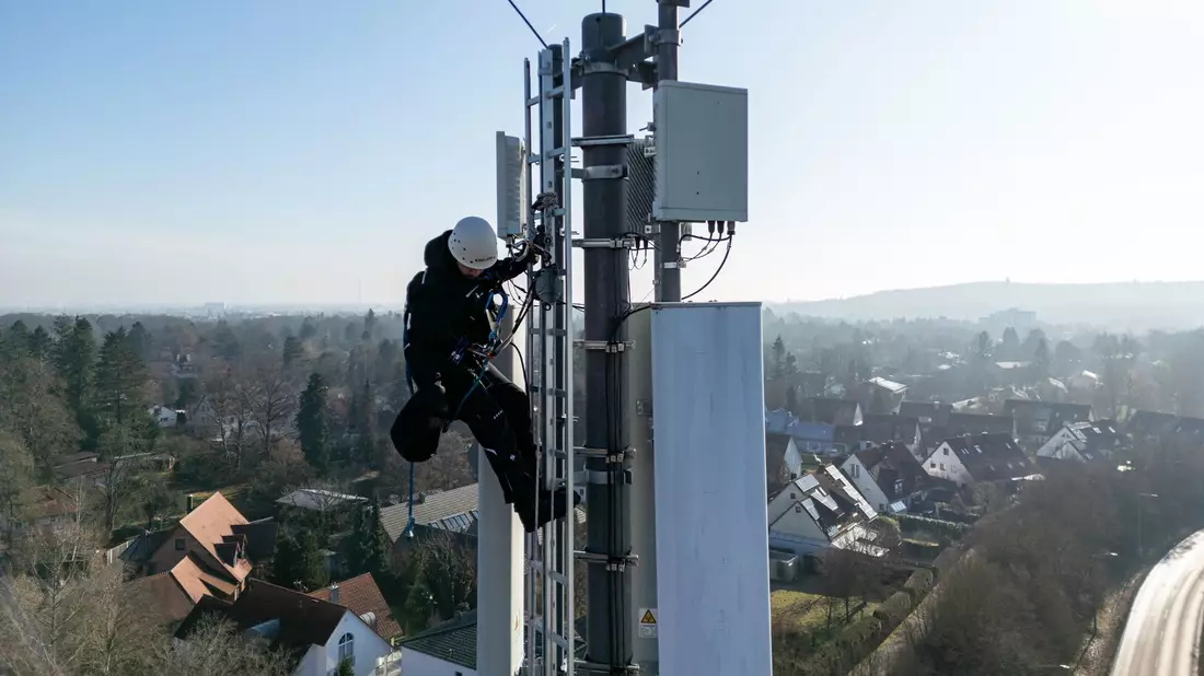 Ein Telekom-Techniker an einem Mobilfunk-Masten - an so einem Standort könnten künftig auch Anti-Drohnen-Sensoren hängen. (Archivbild) - Bild: Daniel Karmann/dpa