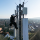 Ein Telekom-Techniker an einem Mobilfunk-Masten - an so einem Standort könnten künftig auch Anti-Drohnen-Sensoren hängen. (Archivbild) - Foto: Daniel Karmann/dpa