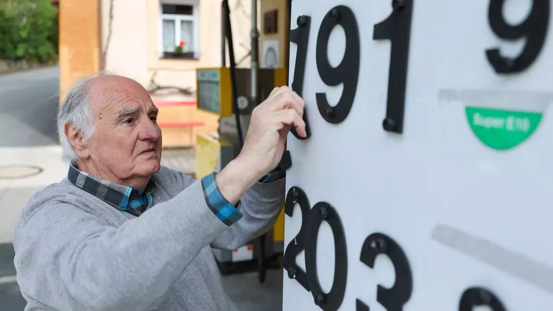 Herbert Brendel passt die Preisanzeige noch händisch an.  - Bild: Daniel Löb/dpa