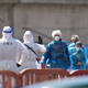 Personen in Schutzbekleidung und mit Masken gehen im Hafen von Granadilla auf Teneriffa an Land. - Foto: Manu Fernandez/AP/dpa