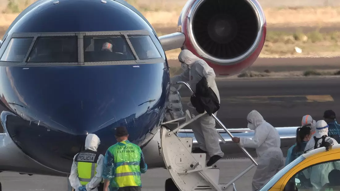 Die Passagiere betraten in Schutzkleidung das Flugzeug.  - Bild: Arturo Rodriguez/AP/dpa