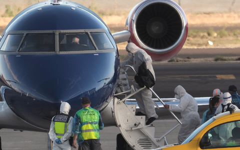 Die Passagiere betraten in Schutzkleidung das Flugzeug.  - Foto: Arturo Rodriguez/AP/dpa