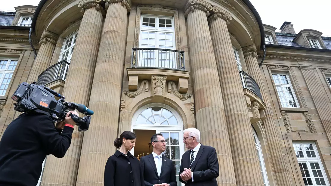 Der alte und der neue Hausherr: Winfried Kretschmann, Cem Özdemir und Özdemirs Ehefrau Flavia Zaka stehen vor der Villa Reitzenstein. - Bild: Bernd Weißbrod/dpa POOL/dpa