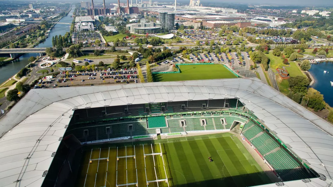 Die VW-Stadt Wolfsburg: im Vordergrund die Volkswagen-Arena, dahinter das Volkswagen-Werk. - Bild: picture alliance / dpa