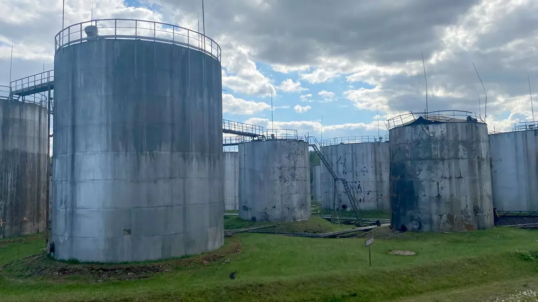Öltanks stehen an der Absturzstelle einer Drohne in einer Lageranlage in Rezekne. - Bild: Alexander Welscher/dpa