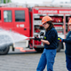 Ilias (links) und Annabella, Mitglieder der Jugendfeuerwehr in Mannheim, halten bei einer Übung einen Feuerwehrschlauch in den Händen. - Foto: Uwe Anspach/dpa