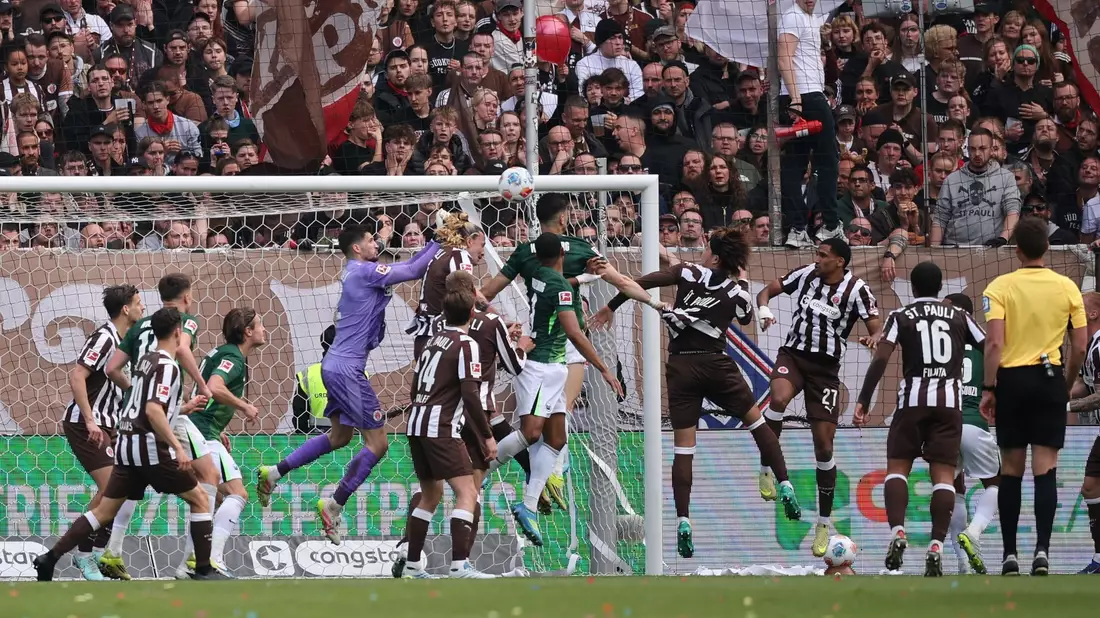 Wolfsburgs Konstantinos Koulierakis (M) traf im Abstiegsgipfel beim FC St. Pauli zum 1:0. - Bild: Christian Charisius/dpa