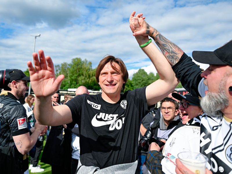 Elversberg-Coach Vincent Wagner jubelt mit den Fans über den Aufstieg.  - Foto: Uwe Anspach/dpa