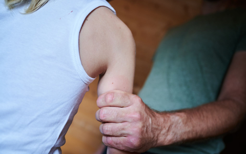 Ein Mann hält ein Kind fest am Arm (gestellte Szene). (Symbolbild) - Foto: Annette Riedl/dpa