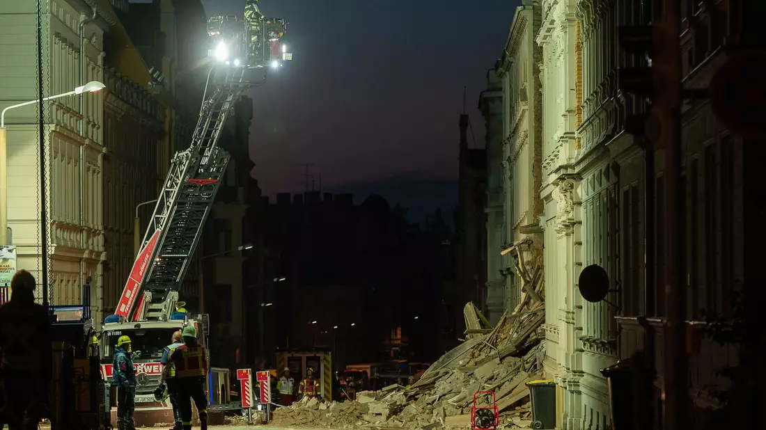 Eine Drehleiter der Feuerwehr ragt über dem Trümmerfeld des eingestürzten Haus in der Innenstadt von Görlitz.  - Bild: Paul Glaser/dpa