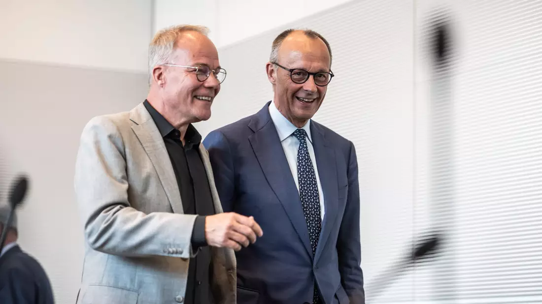 Gute Laune bei SPD-Fraktionschef Miersch und Kanzler Merz, zumindest für diesen Tag. - Bild: Michael Kappeler/dpa