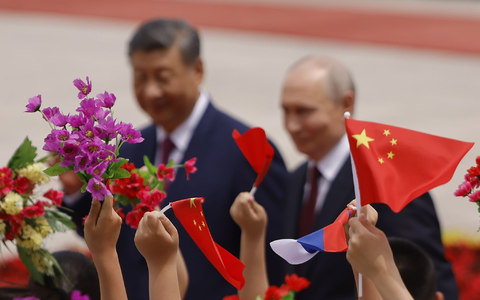 Mit Blumen und Fähnchen empfingen chinesische Kinder den Gast aus Moskau.  - Foto: Maxim Shemetov/Pool Reuters/AP/dpa