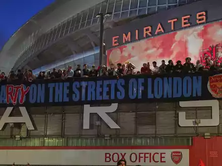 Arsenal-Fans zeigen nach dem Titelgewinn ein Banner am Stadion: «Party auf Londons Straßen» - Foto: Alberto Pezzali/AP/dpa