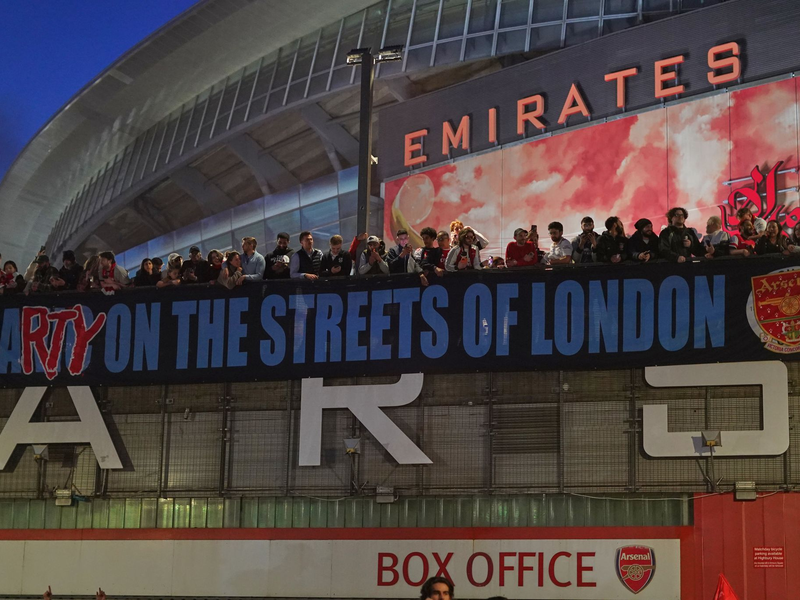 Arsenal-Fans zeigen nach dem Titelgewinn ein Banner am Stadion: «Party auf Londons Straßen» - Foto: Alberto Pezzali/AP/dpa