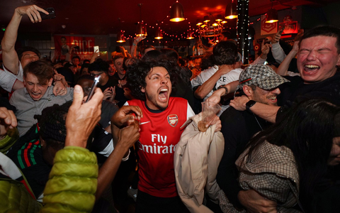 Arsenal-Anhänger feiern in einem Pub in der Nähe des Arsenal-Stadions, nachdem die Fußballmannschaft des FC Arsenal den Titel in der Premier League gewonnen hat. - Foto: Alberto Pezzali/AP/dpa
