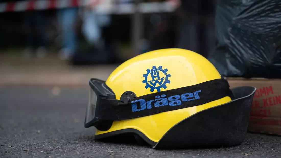 Ein Mitarbeiter des Technischen Hilfswerks hat an der Unglücksstelle in Görlitz seinen Helm abgelegt.  - Bild: Paul Glaser/dpa