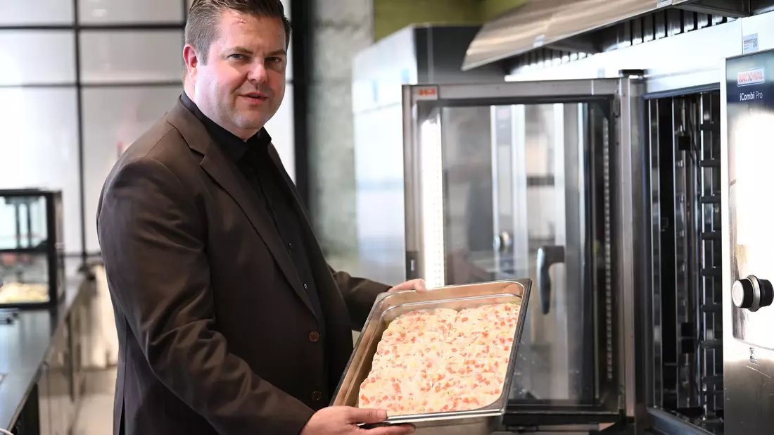 Firmenchef Jan-Peer Laabs hält im Betriebsrestaurant der Apetito-Zentrale eine Schale mit Lachs-Auflauf in der Hand. - Bild: Wolf von Dewitz/dpa