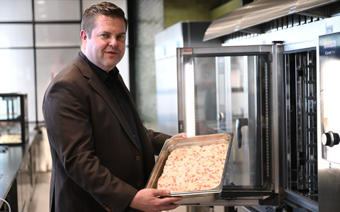 Firmenchef Jan-Peer Laabs hält im Betriebsrestaurant der Apetito-Zentrale eine Schale mit Lachs-Auflauf in der Hand. - Foto: Wolf von Dewitz/dpa
