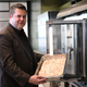 Firmenchef Jan-Peer Laabs hält im Betriebsrestaurant der Apetito-Zentrale eine Schale mit Lachs-Auflauf in der Hand. - Foto: Wolf von Dewitz/dpa