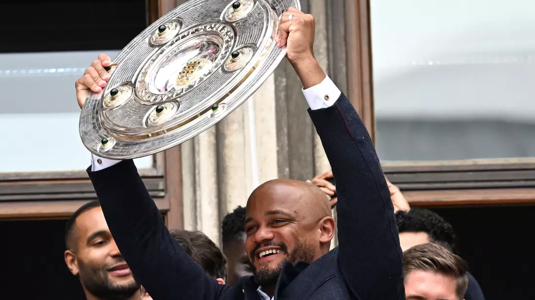 Vincent Kompany reckt die Meisterschale auf dem Münchner Rathausbalkon in die Höhe. (Archivbild) - Bild: Sven Hoppe/dpa