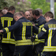 Einsatzkräfte der Feuerwehr reinigen während einer Pause ihre Arbeitsschutzkleidung am Einsatzort. - Foto: Sebastian Kahnert/dpa