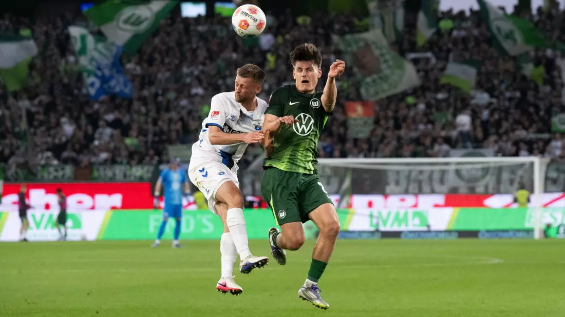 Im Kopfballduell: Wolfsburgs Joakim Maehle (r) und Sebastian Klaas vom SC Paderborn. - Bild: Julian Stratenschulte/dpa