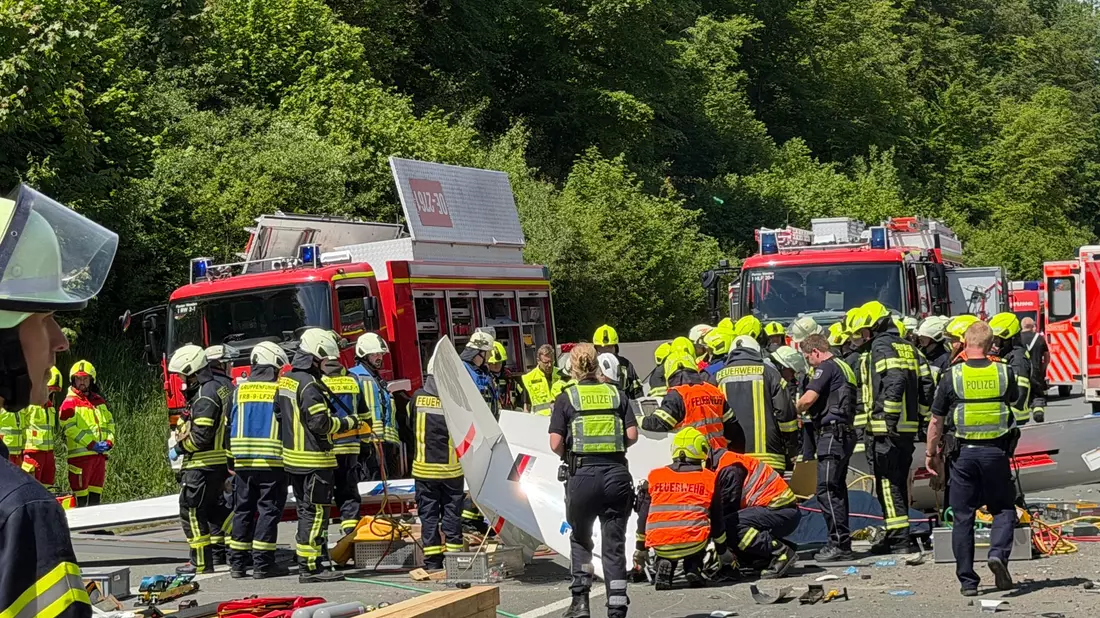 Rettungsdienste und Polizei arbeiten an der Unfallstelle, nachdem ein Segelflugzeug auf die A45 gestürzt ist.  - Bild: Berthold Stamm/dpa