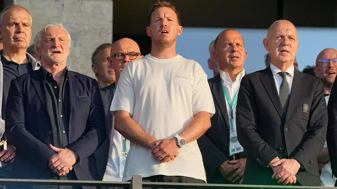 Julian Nagelsmann (m.) steht zwischen DFB-Sportdirektor Rudi Völler (l.) und Verbandschef Bernd Neuendorf (r.) auf der Tribüne des Berliner Olympiastadions.  - Bild: Michael Kappeler/dpa