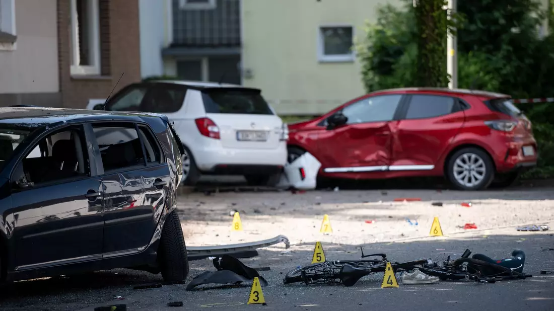 Ein Fahrrad und ein verlorener Schuh liegen auf der Fahrbahn - eine Frau hat mit ihrem Auto drei Kinder angefahren. - Bild: Fabian Strauch/dpa
