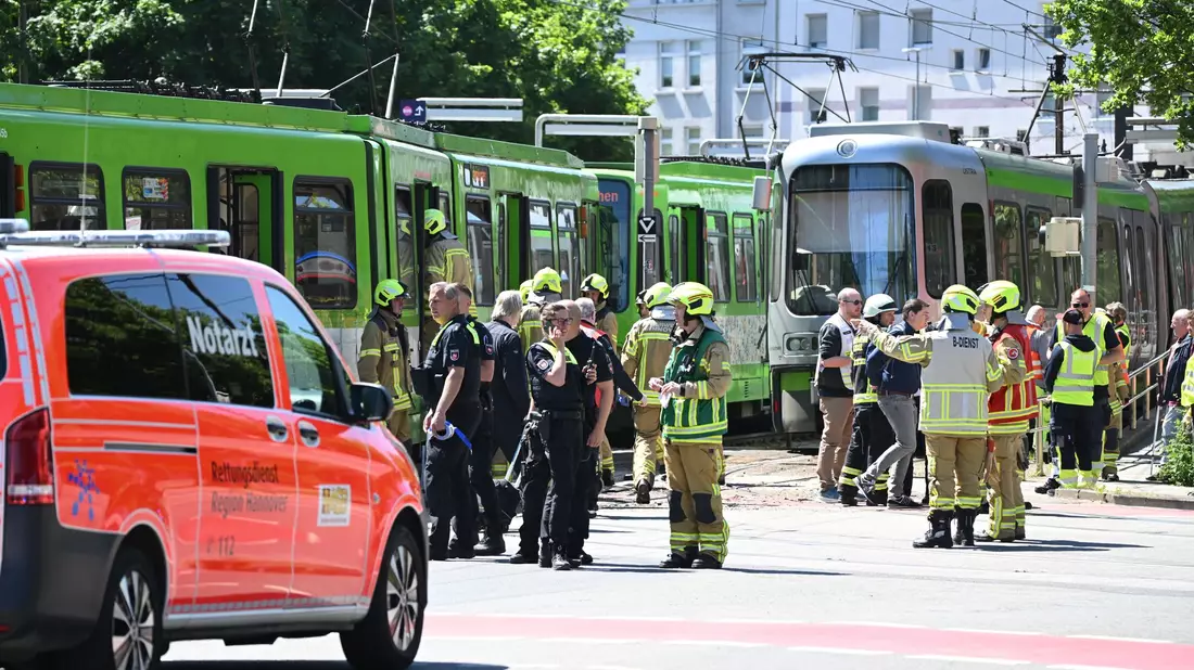 Einsatzkräfte von Polizei und Feuerwehr stehen nach einem Unfall neben zwei Stadtbahnen. - Bild: Julian Stratenschulte/dpa