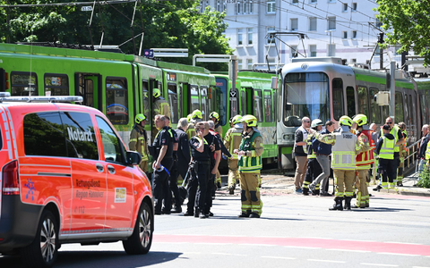 Einsatzkräfte von Polizei und Feuerwehr stehen nach einem Unfall neben zwei Stadtbahnen. - Foto: Julian Stratenschulte/dpa
