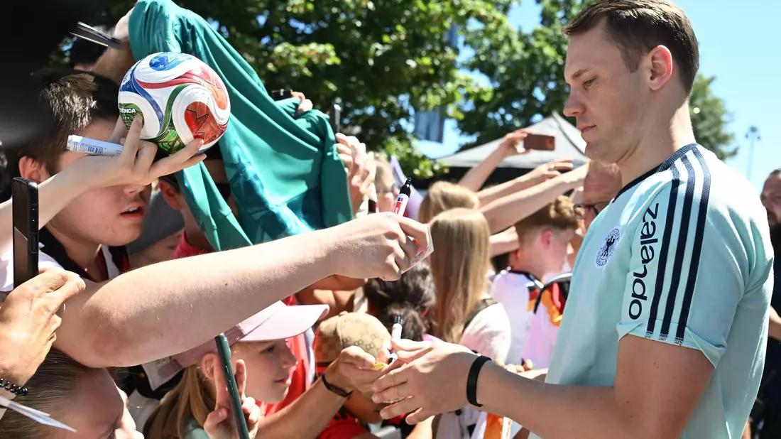 Manuel Neuer schreibt Autogramme.  - Bild: Federico Gambarini/dpa