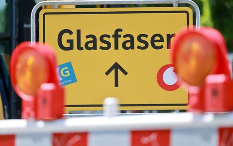 Ein Glasfaser-Schild der Vodafone-Tochter OXG an einer Baustelle. - Foto: Michael Reichel/dpa