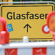 Ein Glasfaser-Schild der Vodafone-Tochter OXG an einer Baustelle. - Foto: Michael Reichel/dpa