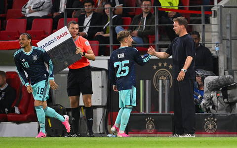 Bundestrainer Nagelsmann (r) klatscht mit Lennart Karl ab. Startet der Bayern-Youngster bei der WM richtig durch?  - Foto: Tom Weller/dpa