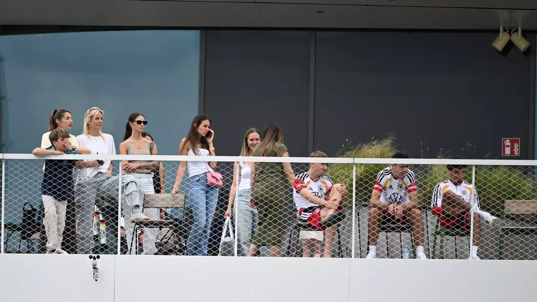 Einige Spielerfrauen und die Frau des Bundestrainers (l) beobachten von einem Balkon das Trainingsspiel der Reservisten auf dem DFB-Campus.  - Bild: Federico Gambarini/dpa