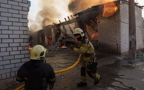Rettungskräfte löschen ein Feuer in einer Kiewer Autowerkstatt, die durch einen russischen Angriff beschädigt wurde. - Bild: Evgeniy Maloletka/AP/dpa