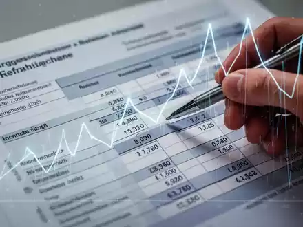 A close-up of a German tax document or spreadsheet with a hand holding a pen, symbolizing income tax reform. - Foto: über boerse-global.de