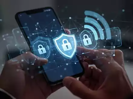 Ein Smartphone-Bildschirm zeigt digitale Sicherheits-Icons wie ein Schild und ein Schloss, während im Hintergrund ein Mobilfunknetz angedeutet wird. - Foto: über boerse-global.de