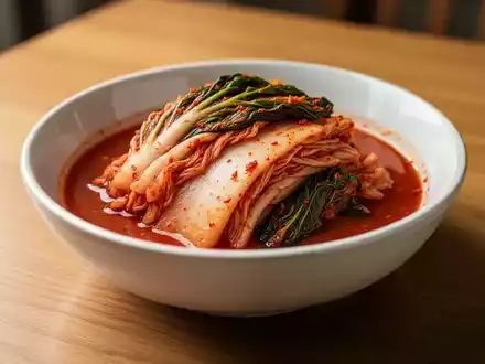 Eine Schale Kimchi auf einem Holztisch, die gesunde Ernährung und Cholesterinsenkung symbolisiert. - Foto: über boerse-global.de