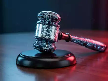 A high-tech gavel with circuit patterns, glowing blue and red, on a wooden surface, representing AI regulation and lawmaking. - Foto: über boerse-global.de