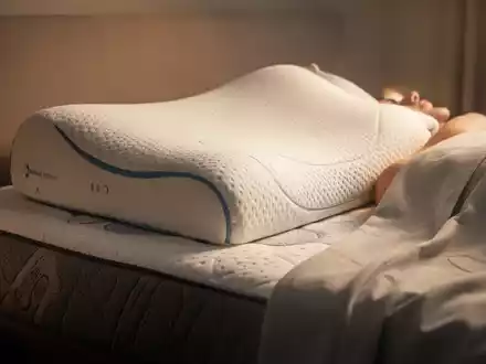Ein stilisiertes, bequemes Bett mit einem ergonomischen Kissen und einer Matratze, beleuchtet von weichem, warmem Licht. - Foto: über boerse-global.de