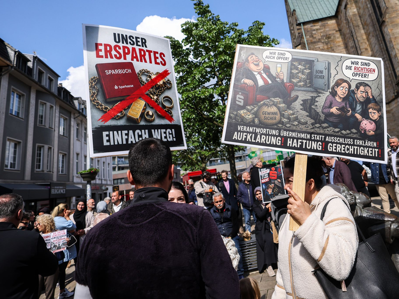 «Unser Erspartes - einfach weg», klagten geschädigte Sparkassenkunden Anfang Mai bei einer Kundgebung in Gelsenkirchen. Jetzt beginnen die ersten Zivilprozesse gegen die Sparkasse. (Archivbild) - Foto: Christoph Reichwein/dpa