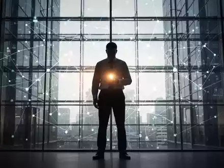Eine schattenhafte Figur in einem modernen Bürogebäude mit einem leuchtenden Licht, das Wahrheit oder Offenlegung symbolisiert. - Foto: über boerse-global.de