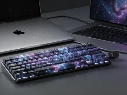 A Lofree Flow 2 mechanical keyboard in a dark blue color next to a silver MacBook Neo laptop on a minimalist desk. - Foto: über boerse-global.de